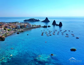 Les rochers volcaniques des Faraglioni et l'île Lachea sur la côte d'Aci Trezza