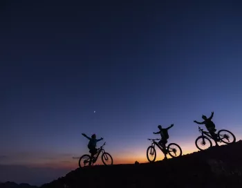 Vététiste utilisant l'assistance électrique sur une piste de cendres noires au sommet du volcan Etna