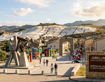 Gibellina en Sicile, capitale italienne de l'art contemporain 2026. Sculptures modernes au premier plan et l'immense Cretto di Burri recouvrant les ruines du séisme du Belice en arrière-plan